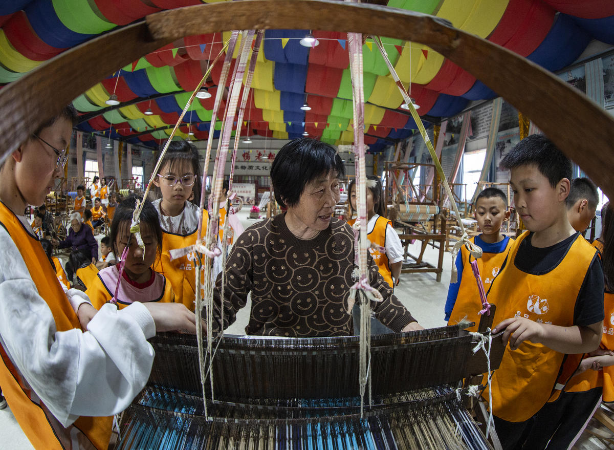 5月1日，在山西省永濟市開張鎮(zhèn)東開張村的惠暢土布文化園，土布制作技師教游客織布技藝。 來源：人民圖片網(wǎng)