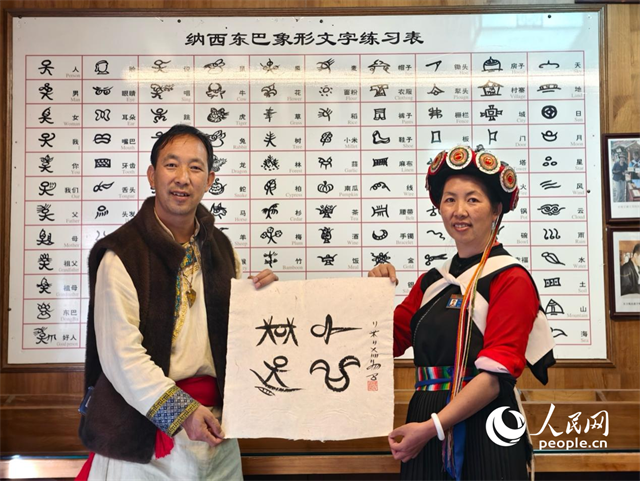 人民網“行進中國”云南調研采訪團走進麗江，和閏元現(xiàn)場用東巴文寫下“行進中國”。人民網記者 符皓攝