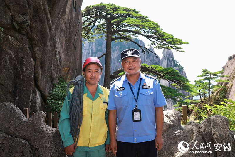 全國(guó)道德模范李培生（左）和胡曉春在迎客松前合影。人民網(wǎng)記者 張俊攝