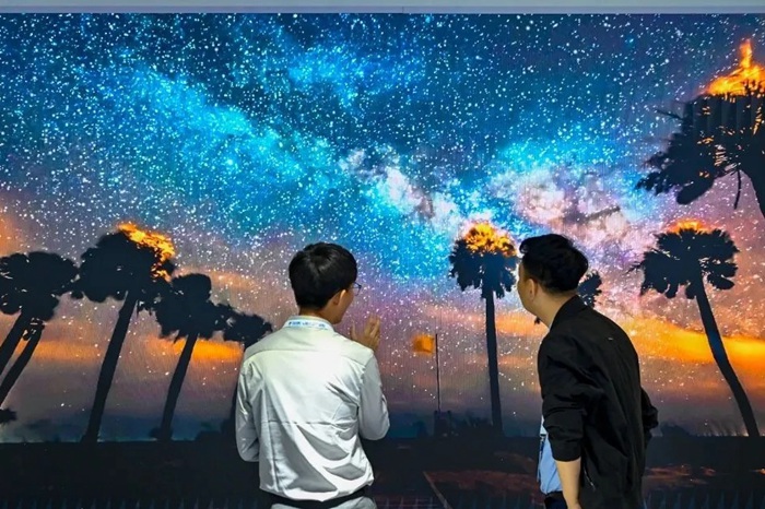 長春光博會希達(dá)電子展區(qū)，一位工作人員正在給一位觀眾講解。（長春新區(qū)供圖）