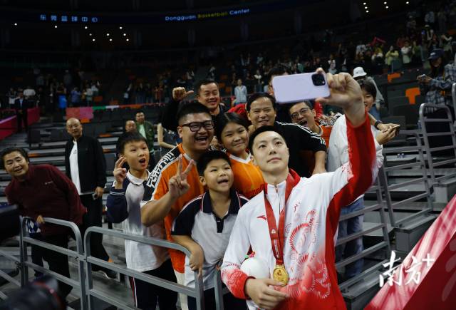 11月12日，十五運會男籃成年組決賽，廣東隊獲得冠軍后，胡明軒與球迷們合影留念。張由瓊 攝