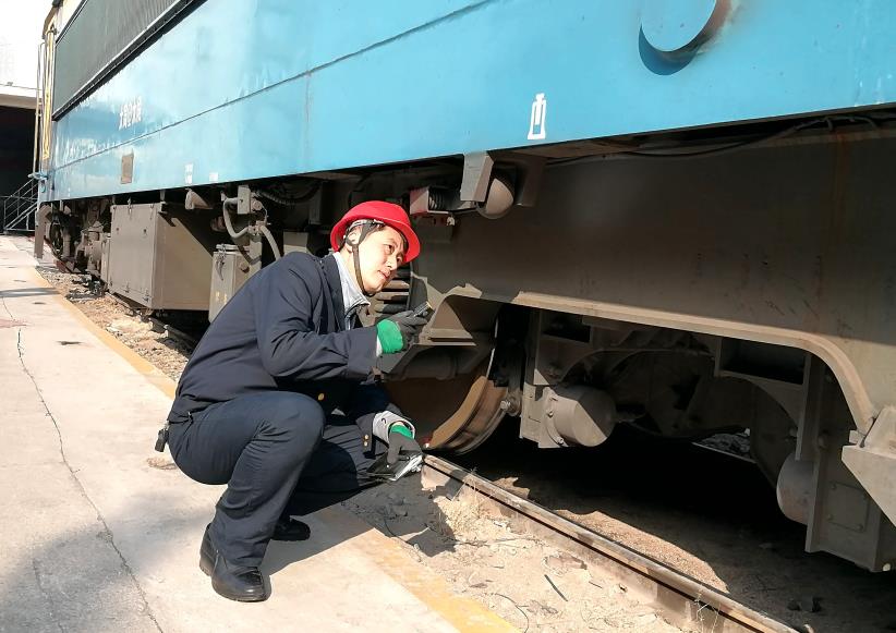 韓文盛全神貫注檢查機車走行部。