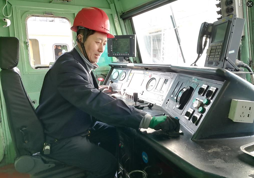 韓文盛正在檢查司機室操作臺。張秋生 攝