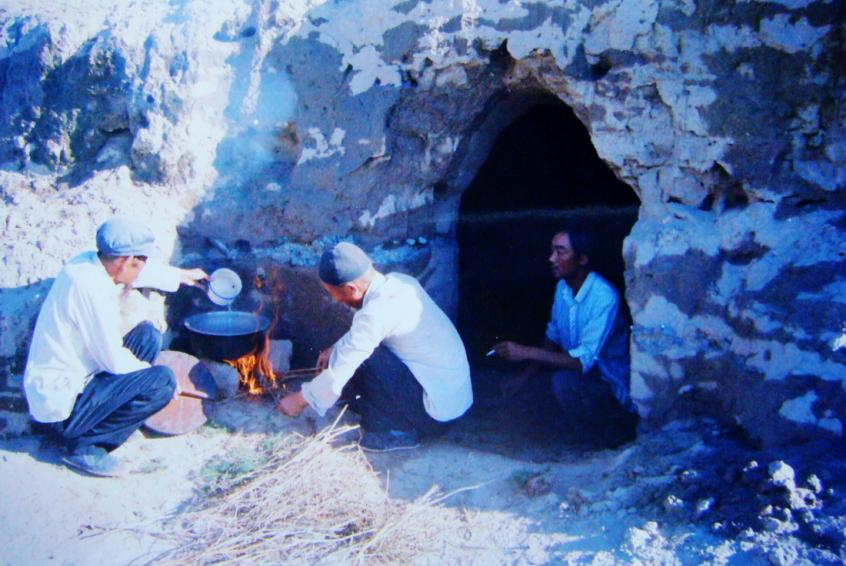 1983年，“六老漢”一代治沙人在“地窩子”生活做飯。新華社發(fā)（八步沙林場供圖）