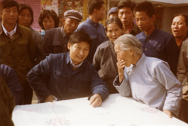 1983年，時(shí)任河北正定縣委書記的習(xí)近平（前排居中），臨時(shí)在大街上擺桌子聽取老百姓意見。