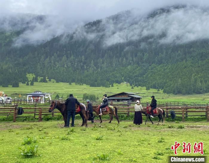 6月10日，游客在魯朗小鎮(zhèn)高山牧場(chǎng)景區(qū)體驗(yàn)騎馬。　冉文娟 攝