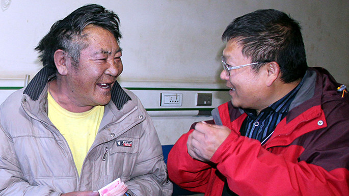 6、這是中國石化援藏干部王鵬雁（右）來到???結對子”幫扶對象的扎扎（左）家中，為他妻子英秋治病送去自掏腰包的??????需的治療費（扎??2014??7??9日攝）_副本.jpg