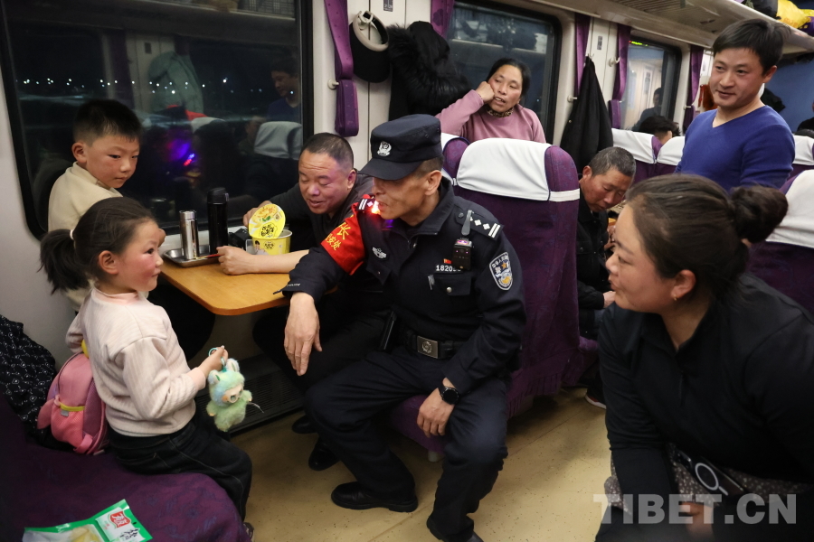 乘警長左紅彬在巡視車廂間隙，向攜帶兒童的旅客專門叮囑安全注意事項。.JPG