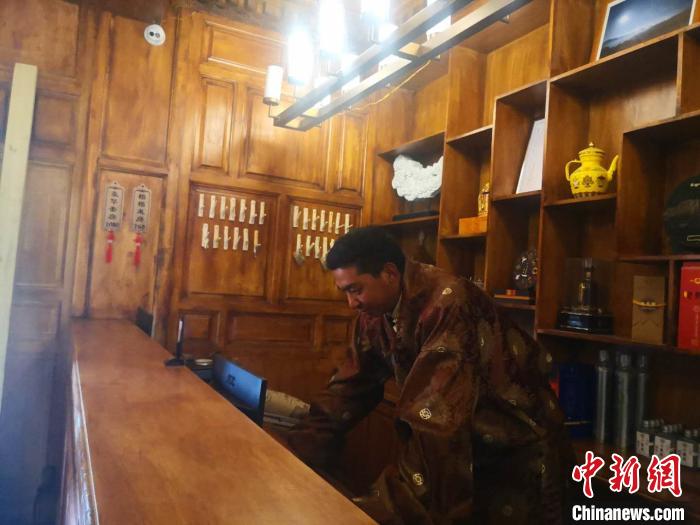 圖為桑杰才讓用電腦處理財(cái)務(wù)?！∈缝o靜 攝