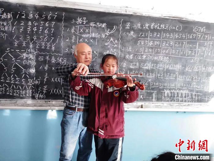 圖為趙興洲教學(xué)生拉小提琴。受訪者提供