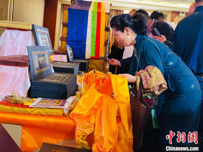 圖為現(xiàn)場藏族民眾向黃金書寫的大藏經(jīng)《甘珠爾》敬獻(xiàn)哈達(dá)?！O睿 攝