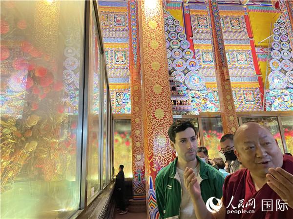 7月25日，省級非物質(zhì)文化遺產(chǎn)項目塔爾寺酥油花的代表性傳承人朋措堅參（右）在塔爾寺酥油花館講解酥油花的制作過程。人民網(wǎng) 謝瑩攝