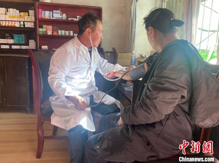 索木滾(左)為村民看病?！∪捞量h委宣傳部供圖