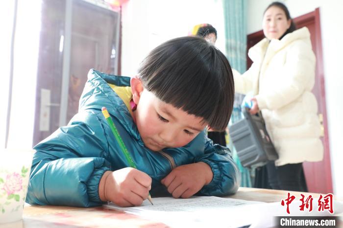 孩子們?cè)诩议T口上學(xué)，是楊周馬草搬入蘭州新家最為開心的事情。小女兒楊洋正在學(xué)習(xí)寫數(shù)字?！∥航ㄜ?攝