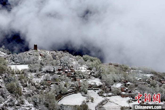 雪后的藏寨和碉樓構(gòu)成美麗的雪景?！〗党鯘衫?攝