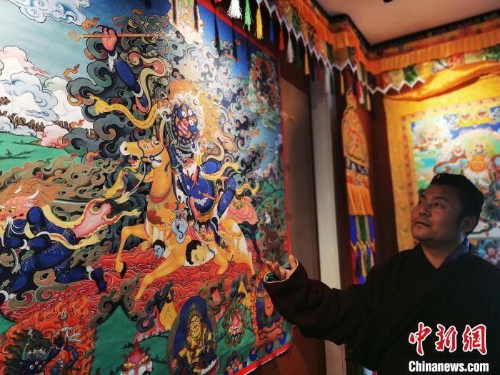 圖為久美尖措展示唐卡作品。　張?zhí)砀?攝