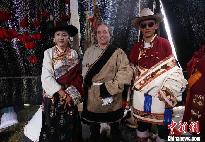 圖為一名外籍攝影師(中)身穿藏服和藏族民眾合影留念?！●R銘言 攝