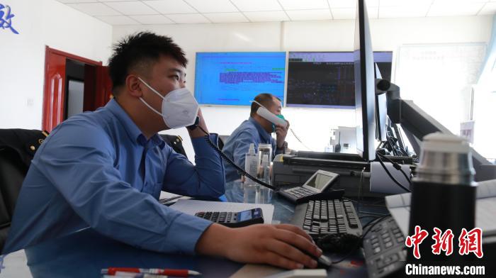 圖為貨運調(diào)度人員與外勤工作人員聯(lián)系掌握車輛裝載情況?！±钌?攝