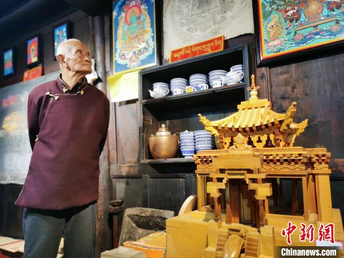 圖為古堡內的藝人桑杰展示自己的雕刻作品?！?zhí)砀?攝