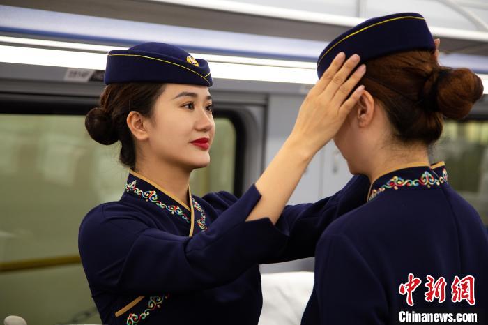 圖為青藏鐵路西格段“復興號”動車組乘務員互相整理新制服?！±罾?攝