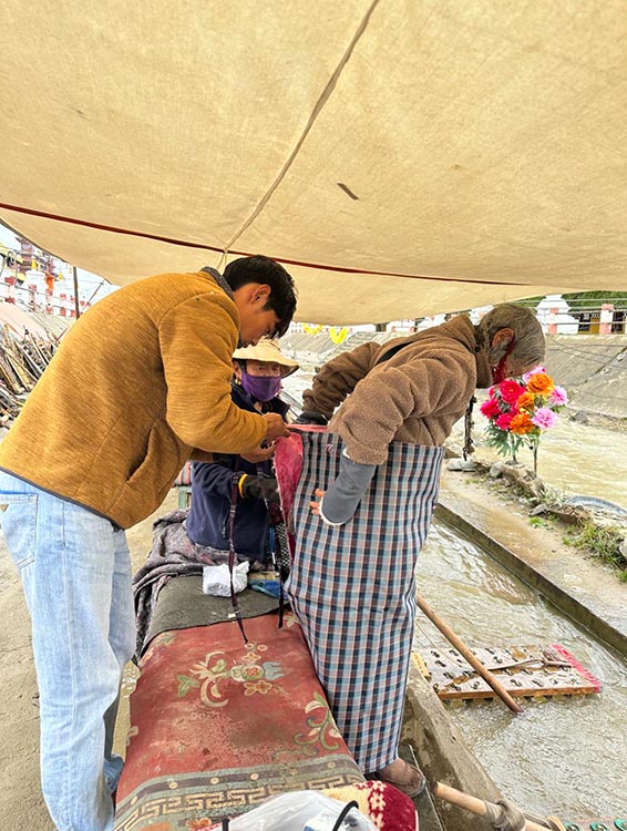 扎西奪爾登為路邊老人送去保暖圍腰。阿壩州文明辦供圖