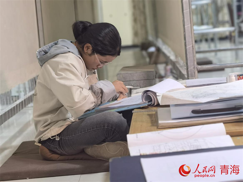 正在學(xué)習(xí)畫底稿的尕讓旺姆。人民網(wǎng) 陳明菊攝