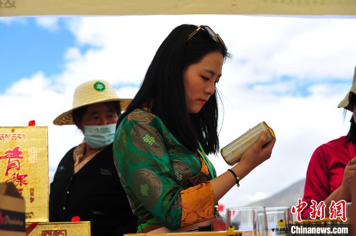 圖為拉薩市民在特色農(nóng)畜產(chǎn)品展示展銷會上選購商品?！垈?攝