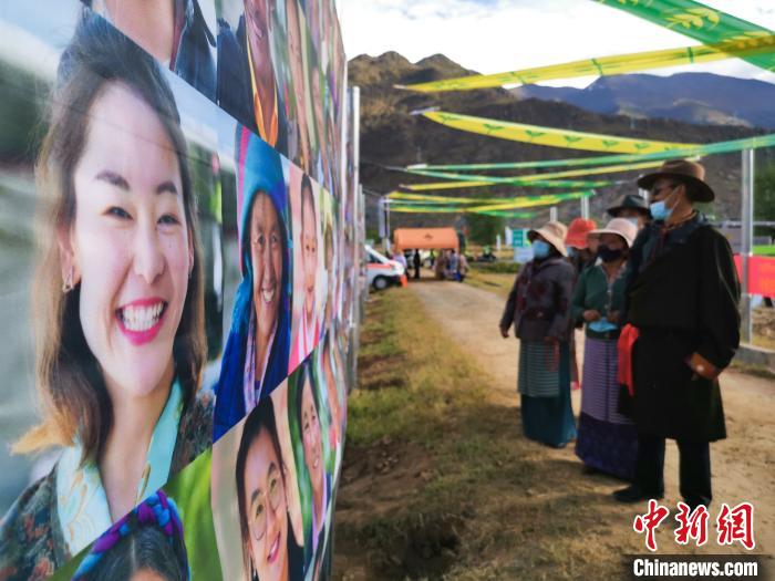 圖為當?shù)孛癖娫谟^看展板上的笑臉。　張偉 攝
