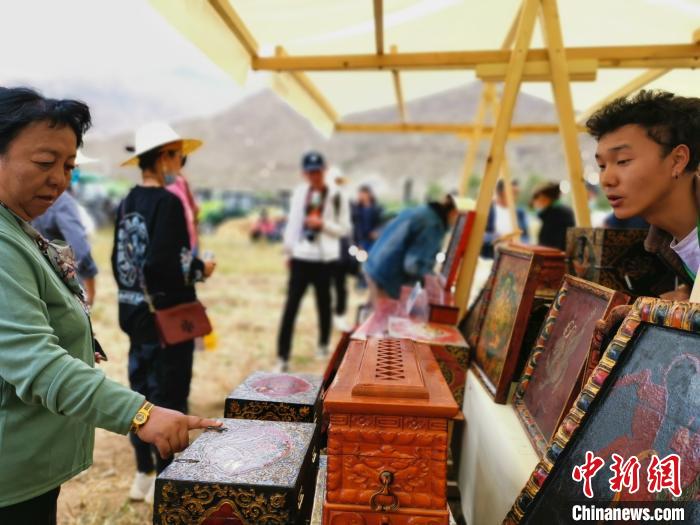 圖為拉薩市民在特色農(nóng)畜產(chǎn)品展示展銷會上選購商品?！垈?攝