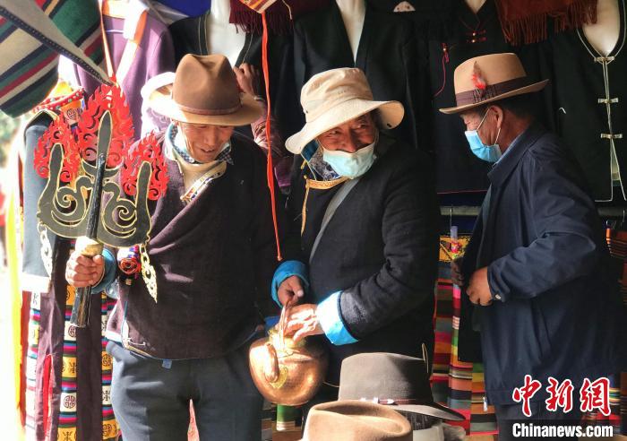 圖為三位藏族老人在集市上聊天交談?！∪轿木?攝