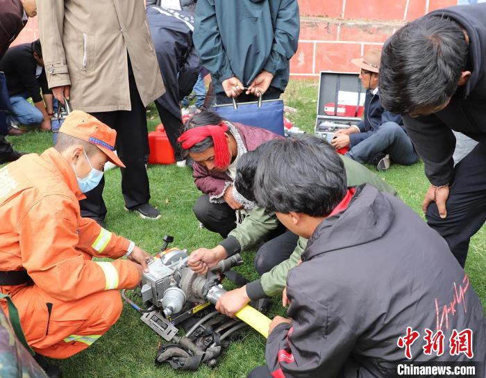 圖為森林消防員為護林員講解滅火裝備的使用方法?！〔际猩窒乐ш?供圖