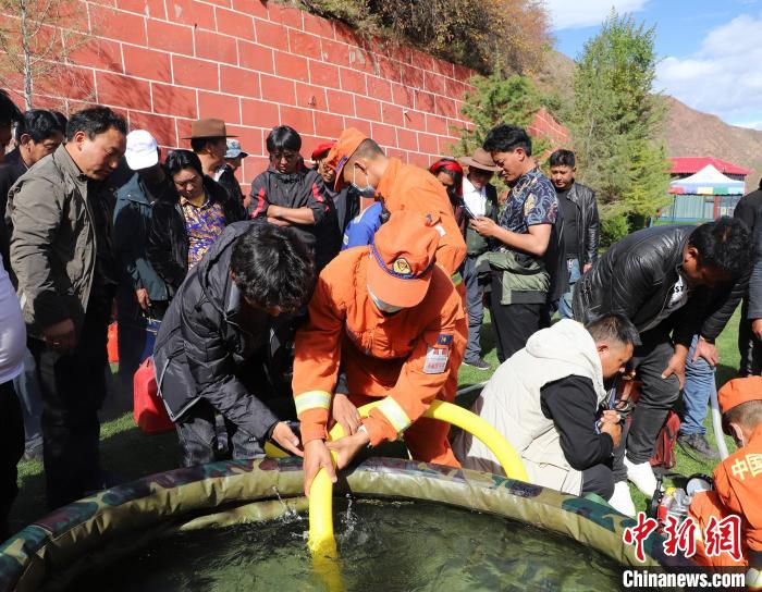 圖為森林消防員為護林員講解滅火裝備的使用方法。　昌都市森林消防支隊 供圖
