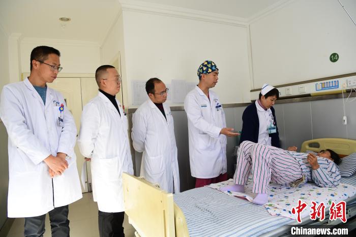 圖為何蔚副主任醫(yī)師(站右二)及團隊術后指導患者進行腰背肌鍛煉?！∝暩聛硭?攝