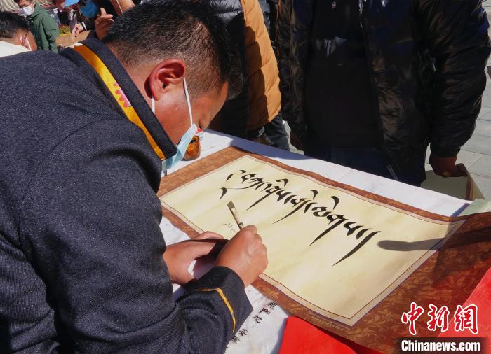 圖為書法家展示藏文書法?！∪轿木?攝