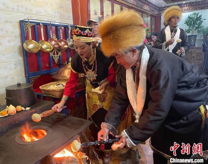 圖為人們?cè)诨鹕峡竟?jié)日美食“結(jié)達(dá)”?！∪轿木?攝