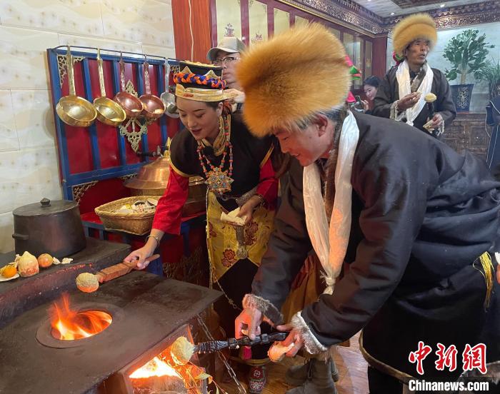 圖為人們在火上烤節(jié)日美食“結(jié)達(dá)”。　冉文娟 攝
