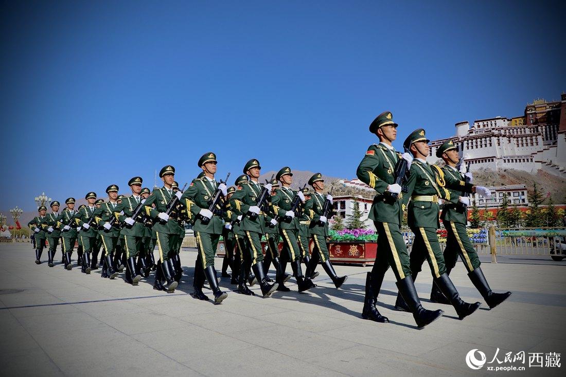 國旗護(hù)衛(wèi)隊(duì)隊(duì)員緊握鋼槍，踏著威武雄壯的步伐，走向國旗臺(tái)。人民網(wǎng) 次仁羅布攝