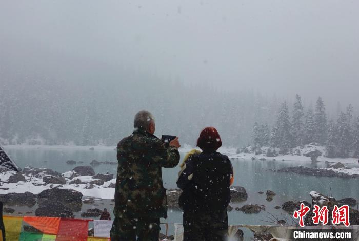 游客欣賞雪中然烏湖。　冉文娟 攝