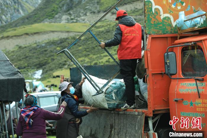 圖為工作人員幫助牧民們卸家具?！÷蹇?攝