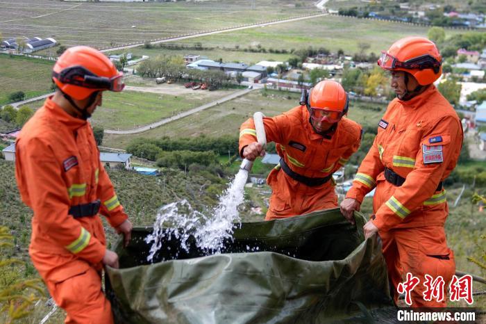 技能大練兵過程中，消防員在陡坡上向蓄水池注水?！±顕鵂c 攝