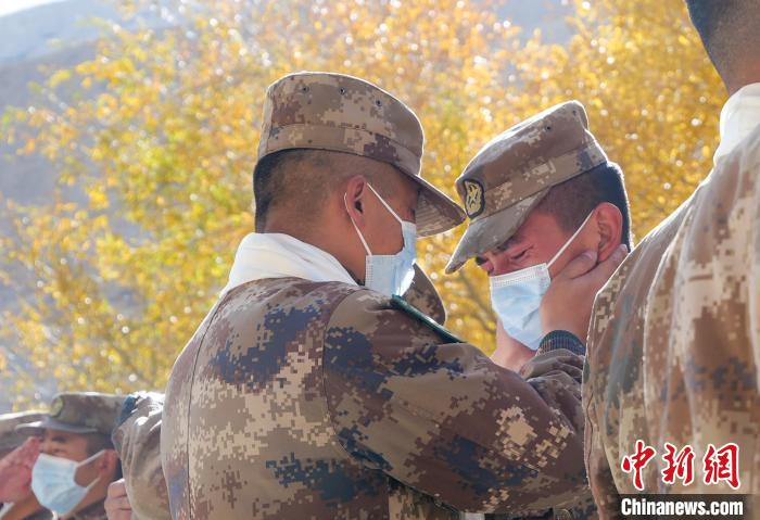 圖為什布奇邊防連退伍老兵與戰(zhàn)友相擁而泣，依依惜別?！⌒觳?攝