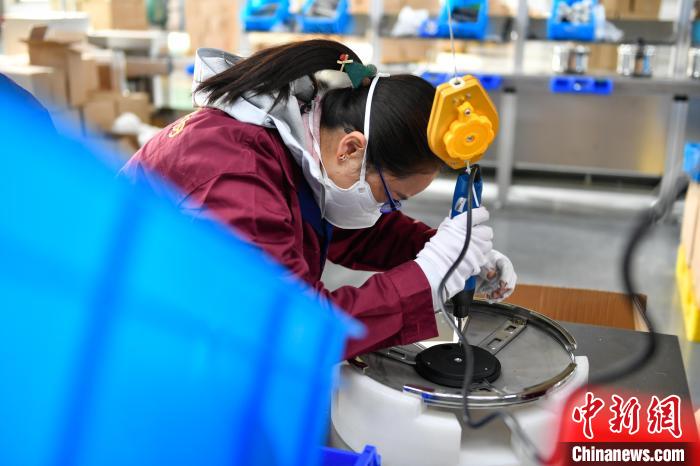 圖為工人正在組裝炊具?！∝暩聛硭?攝
