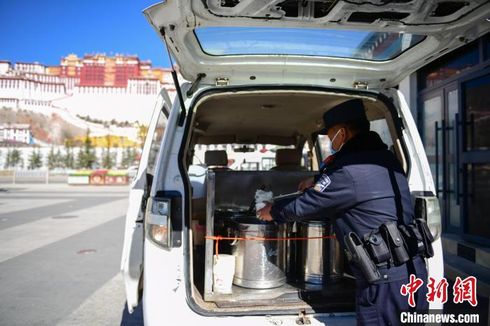 圖為1月23日，布達(dá)拉宮廣場派出所民警正在打午飯?！∝暩聛硭?攝