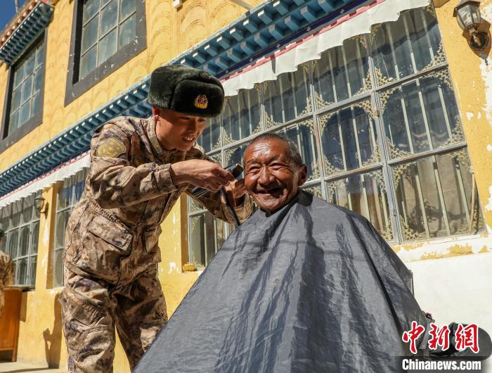 圖為阿里軍分區(qū)某邊防團(tuán)官兵為駐地群眾理發(fā)迎藏歷新年?！〉┰鰝愔?攝