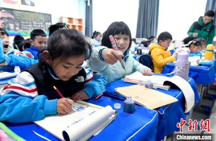 3月14日，西藏拉薩市第一小學(xué)一年級(jí)六班學(xué)生白瑪朗珍(圖左)在藏語文課上書寫藏文?！±盍?攝