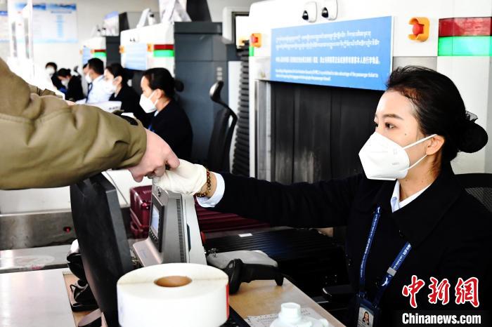 圖為機場工作人員為旅客辦理行李托運?！≈芎?攝