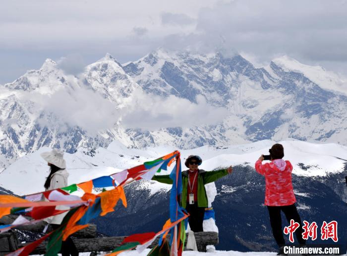 圖為5月14日，西藏林芝色季拉山觀景臺(tái)，游客與南迦巴瓦峰合影?！±盍?攝