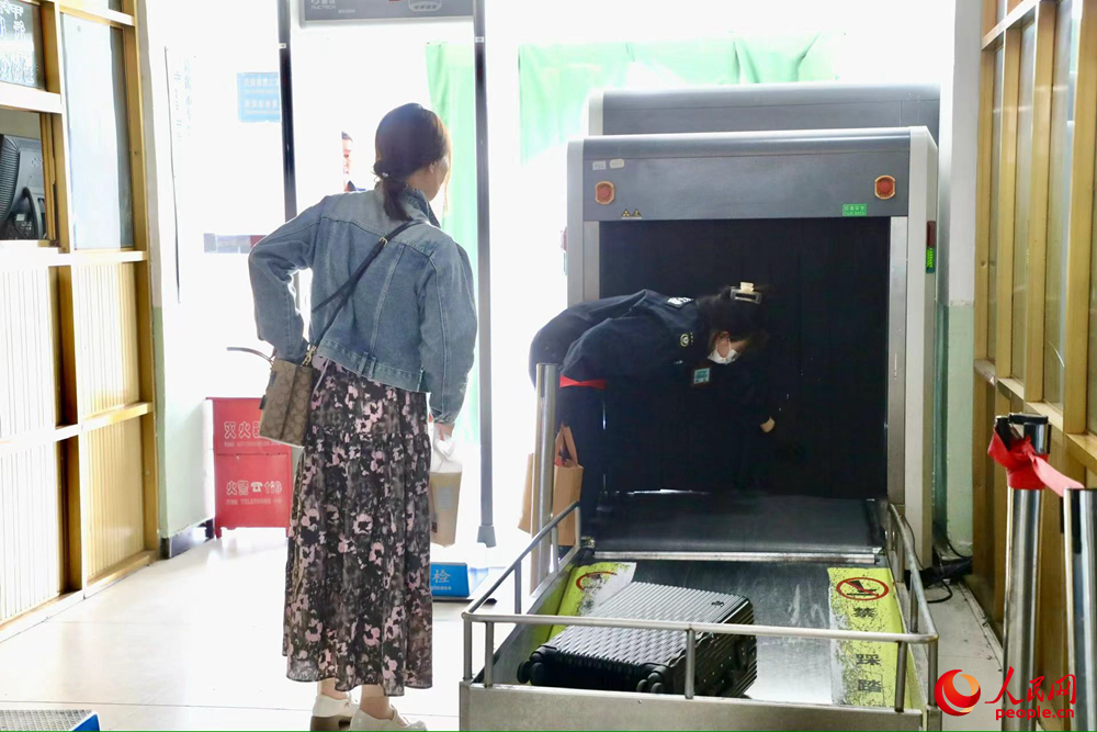 車(chē)站工作人員幫旅客提取行李。人民網(wǎng)記者 次仁羅布攝