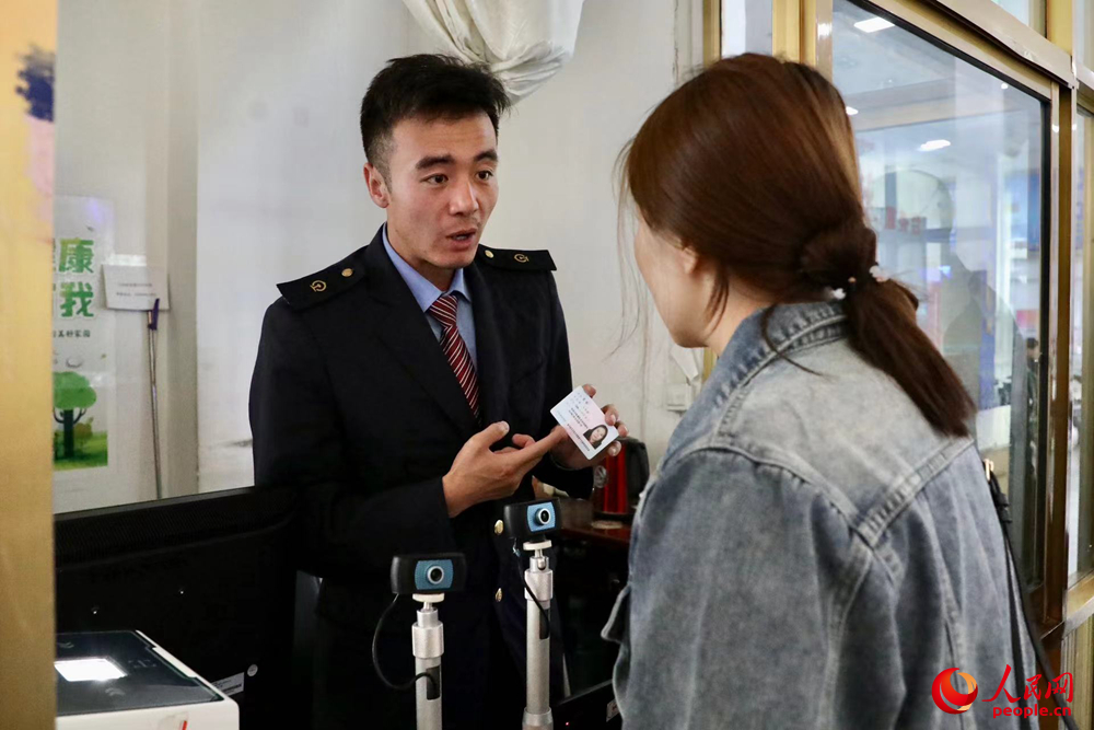 車(chē)站工作人員向旅客解答疑問(wèn)。人民網(wǎng)記者 次仁羅布攝