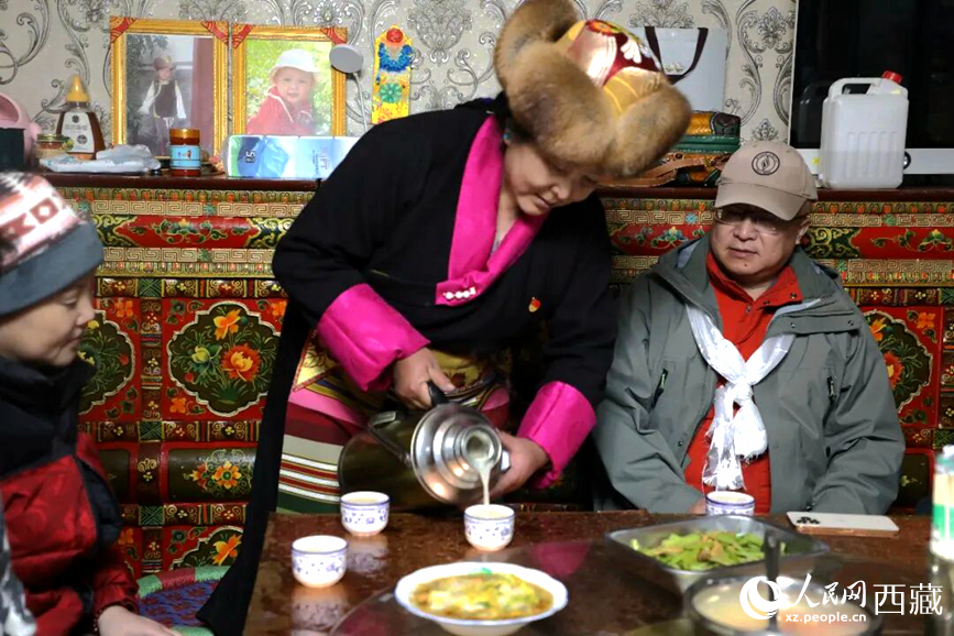 扎西曲登社區(qū)的居民在家中熱情招待遠(yuǎn)道而來的游客。居民身著盛裝，為游客倒上熱騰騰的酥油茶，桌上擺放著切瑪與特色美食，賓主共話民族團(tuán)結(jié)情誼。人民網(wǎng)記者 吳雨仁攝